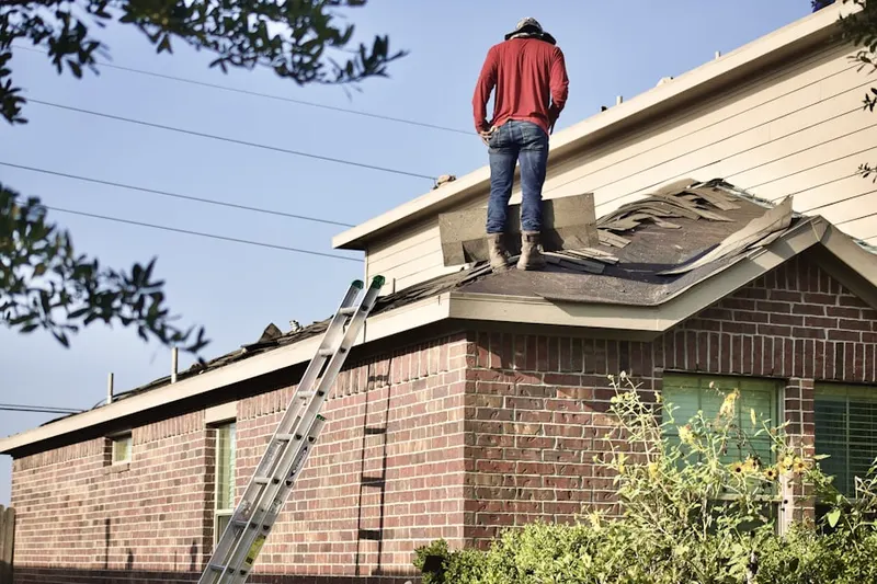 Professional roofer working on a residential roof in Armada